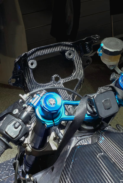 Close-up of a motorcycle's handlebar and control mechanisms with a blue throttle grip.