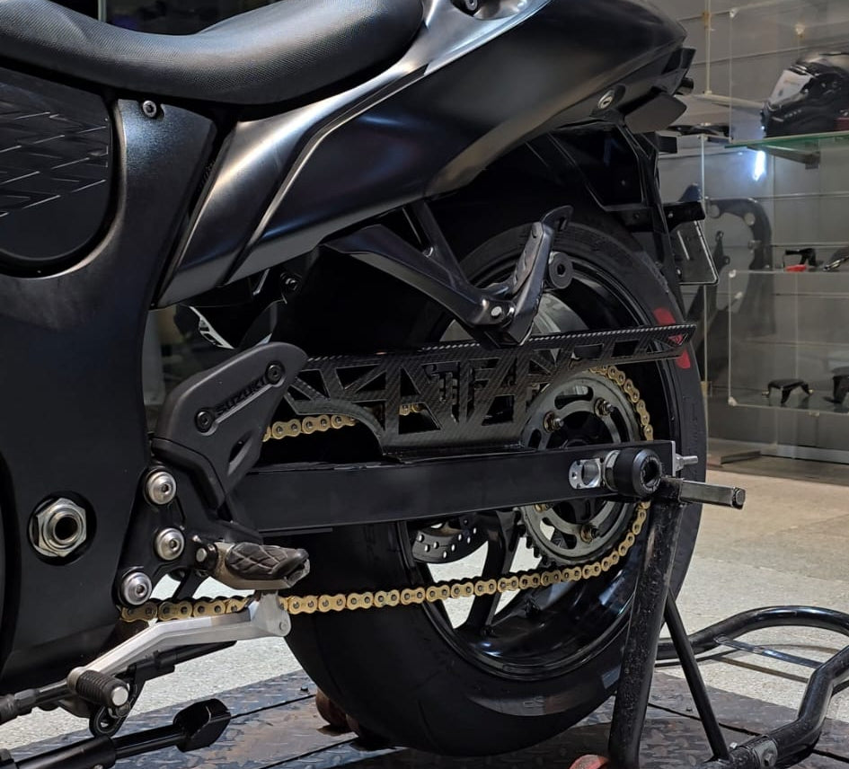 A black sport motorcycle shown from the rear three-quarter angle, mounted on a stand in an indoor showroom or garage setting.